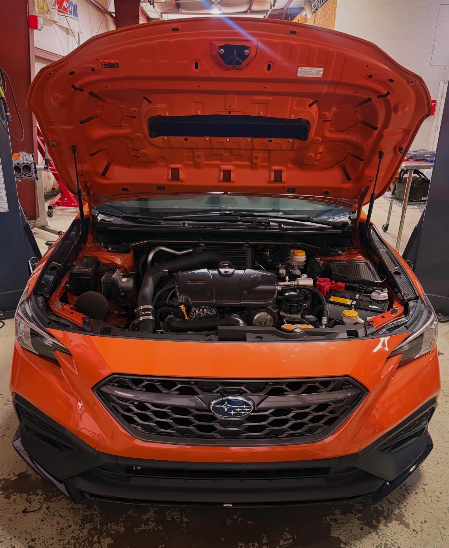 Cinderelli, the orange 2024 Subaru WRX in the AWD Tuning shop